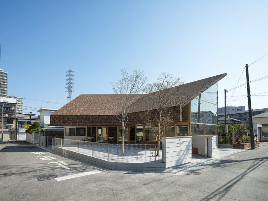 Вид на библиотеку от Yukawa Design Lab: изогнутый фасад и крыша, покрытая черепицей.