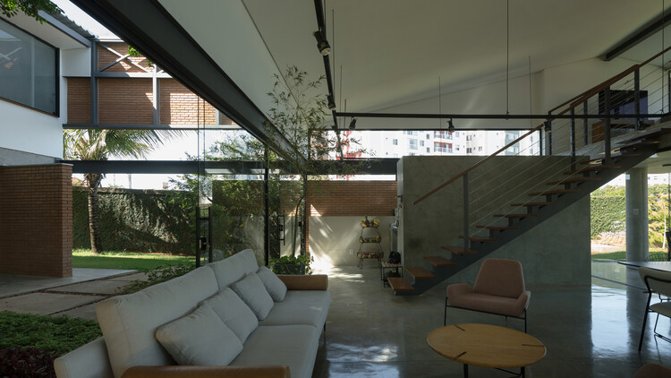 Дом Montes Claros / Venta Arquitetos - Фотография интерьера, гостиная, окна, стол, балка