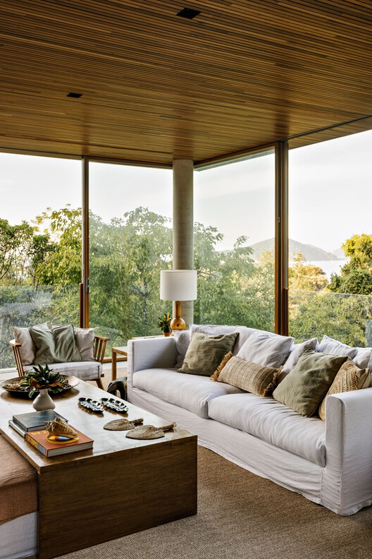 VJC Iporanga House / David Bastos + Marina Salles Arquitetura e Interiores - Фотография интерьера, гостиная, диван, стол