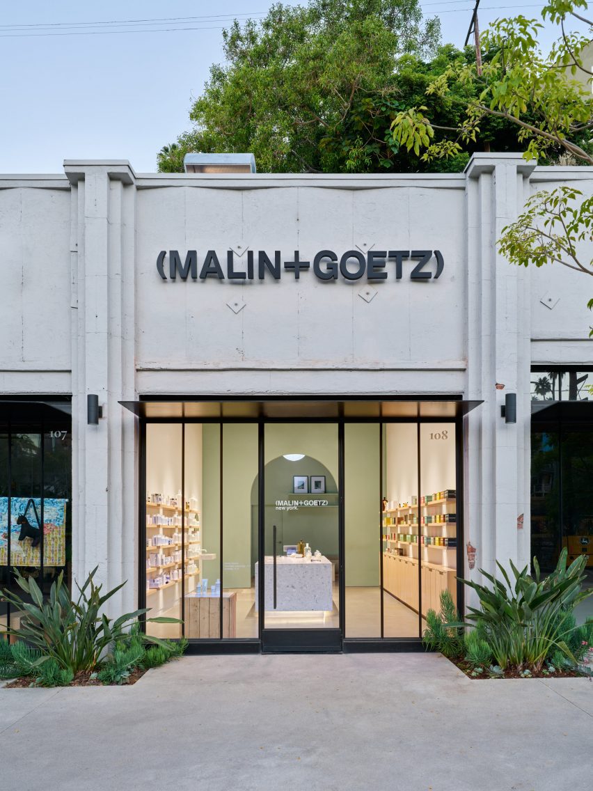 Фасад в стиле ар-деко с логотипом Malin+Goetz над застекленной витриной магазина.
