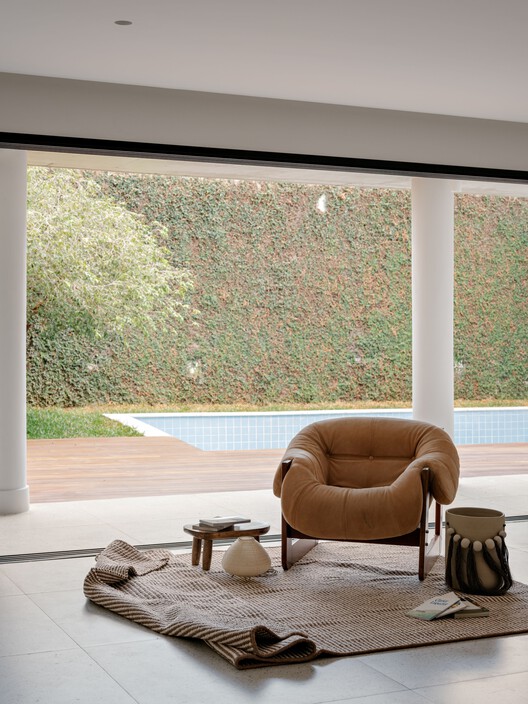 Дом по соседству / Guelo Nunes Arquitetura - Интерьерная фотография, гостиная, дерево, освещение, кресло