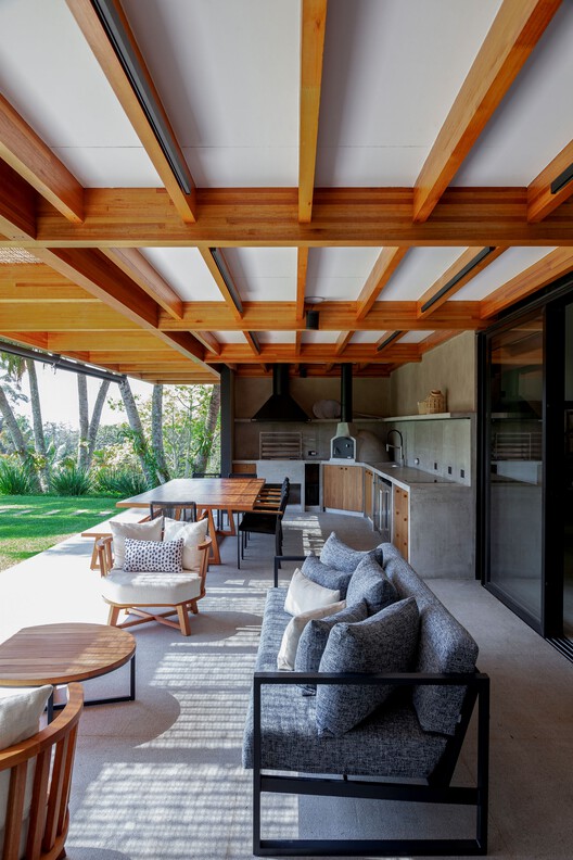 Дом CF / Sandra Sayeg Tranchesi Arquitetura - Интерьерная фотография, гостиная, дерево, стол, стул, луч, патио, палуба